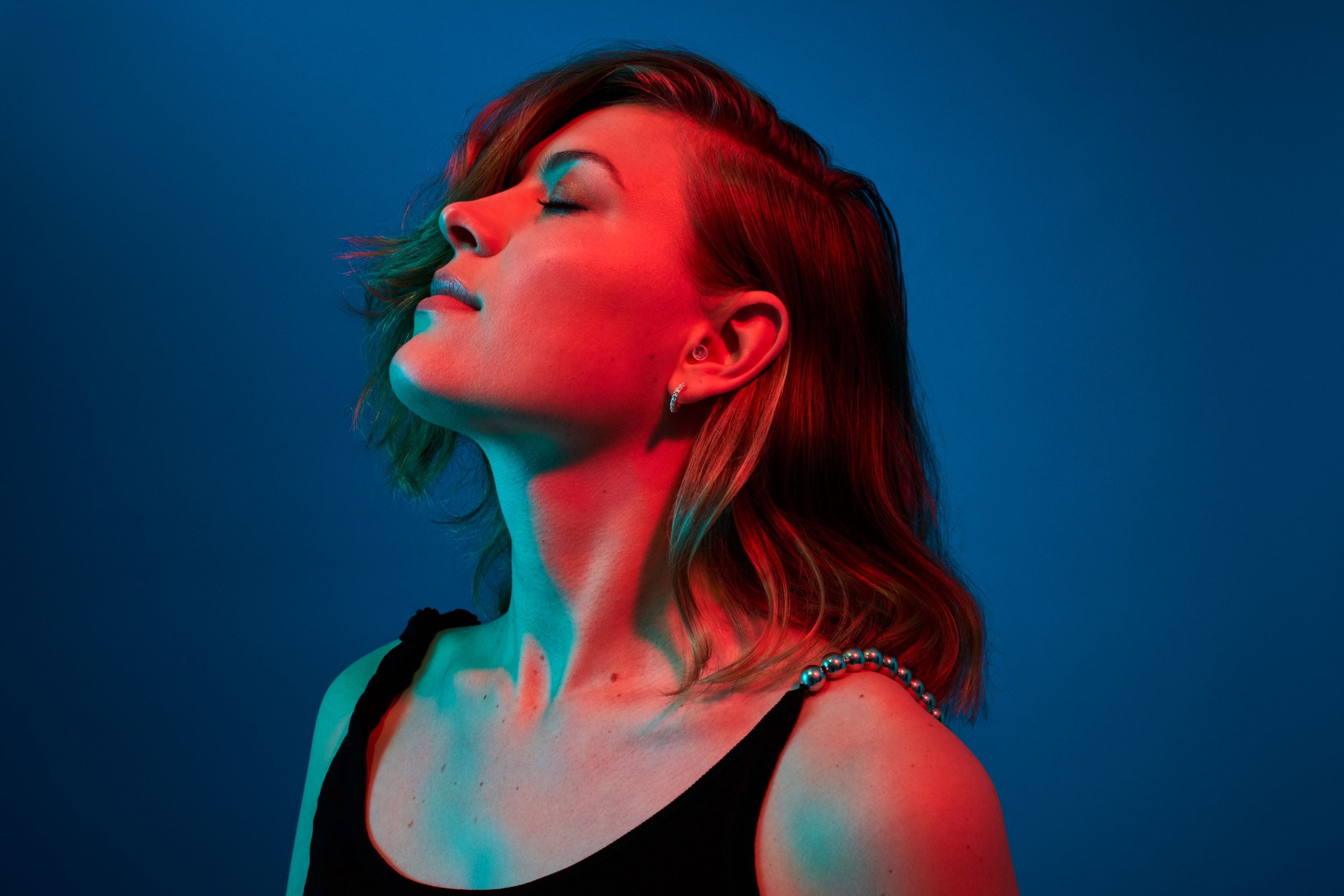 Femme portant des bouchons d’oreilles Alpine PartyPlug transparents lors d’une fête