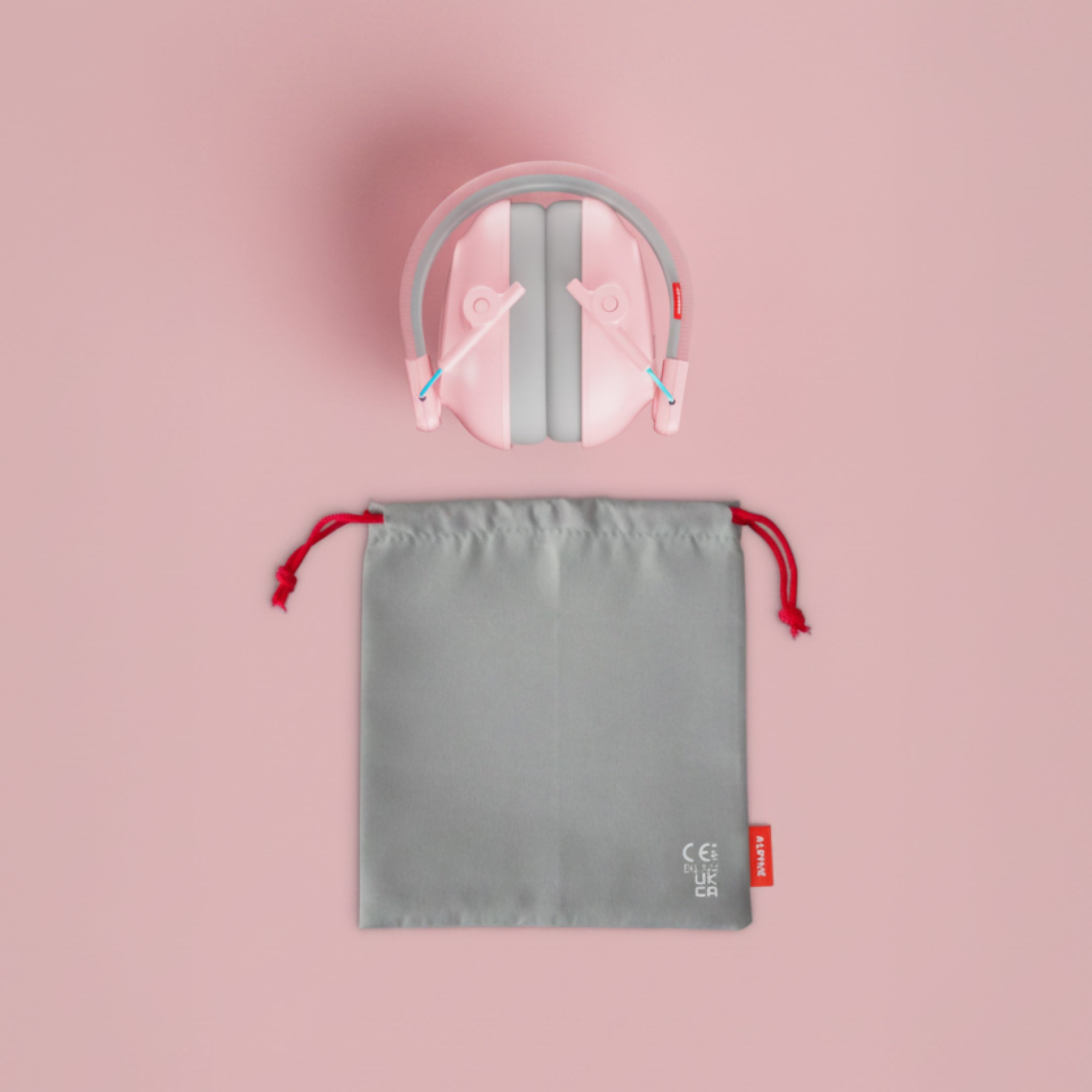Alpine Muffy Baby ear defenders in pink, folded, with grey carrying pouch 