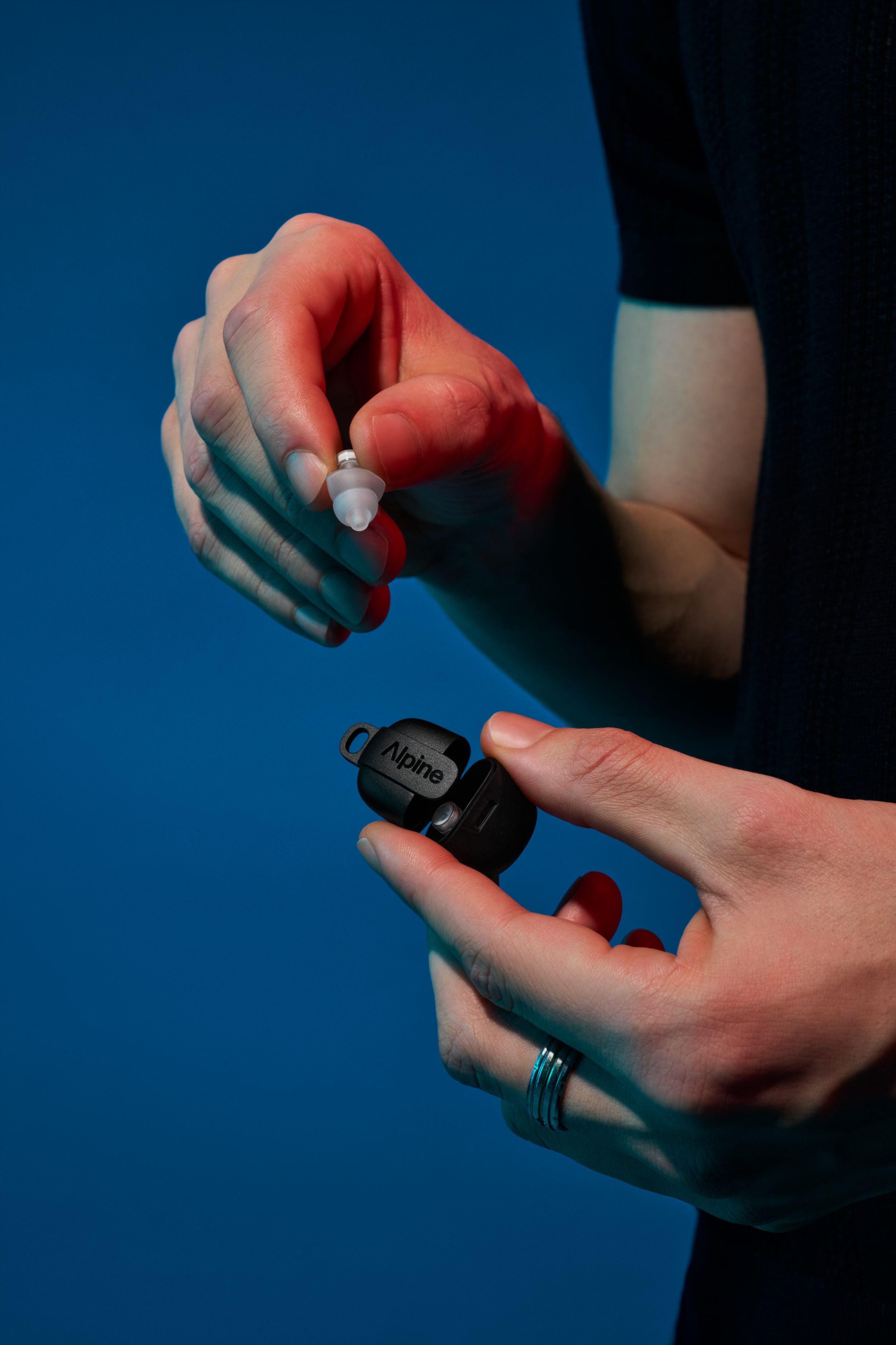 Homme avec Alpine PartyPlug Pro dans un étui transparent